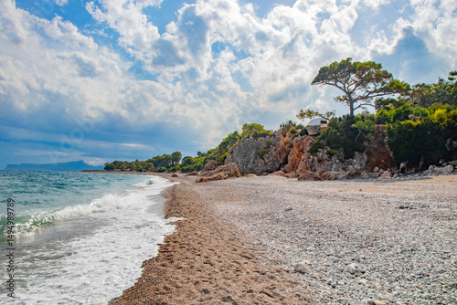 Fototapeta Naklejka Na Ścianę i Meble -  beautiful beach with rocks, pebbles and fir trees in Kemer Turkey in September