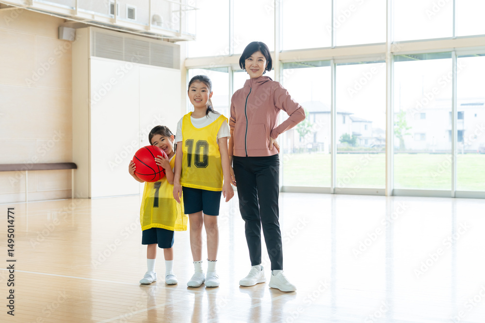 Obraz premium バスケットボールをする子供たちと女性コーチ