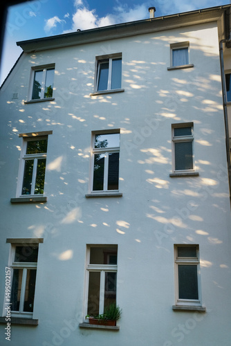 Windows of a residential building in the morning, sun reflections on the walls. Abstract
