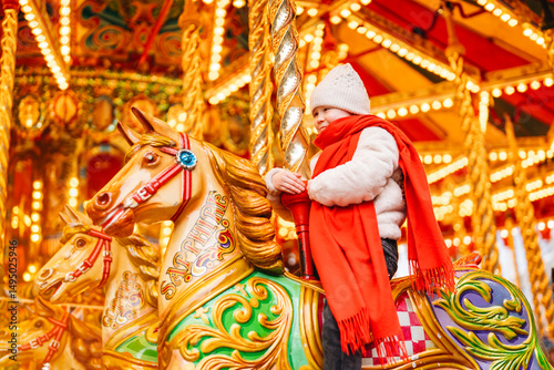 Child enjoying a carousel ride at a festive fairground in winter, surrounded by bright lights and colorful decorations