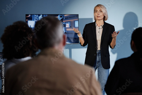 Konstfotografi Medium full shot of female speaker delivering presentation on integrating AI int