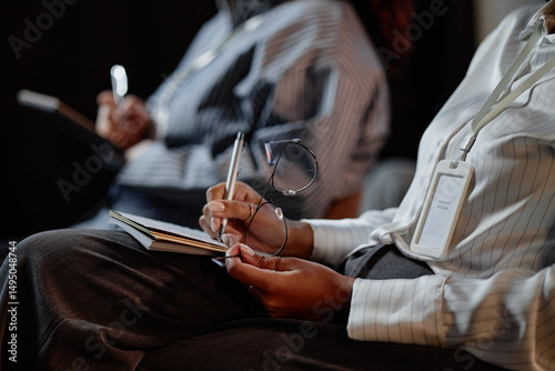 Wall Mural Close up on Black female conference participant holding glasses in hand while ke