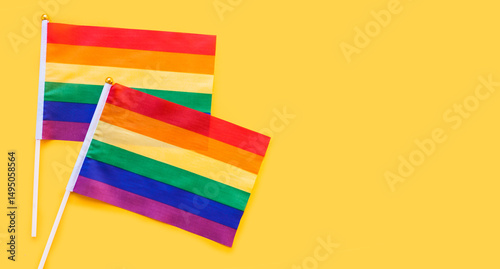 LGBT rainbow flag flat lay on yellow color background. gay marriage, human rights, june parade, lgbtq proud history month concept, coming out day. top view, place for text or logo