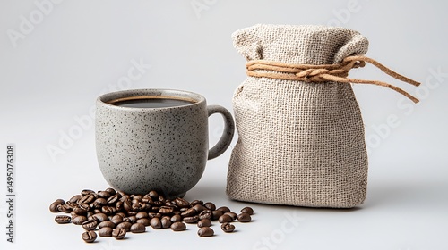Dark coffee in gray mug, beside burlap bag and coffee beans