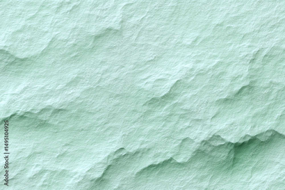 Obraz premium A close-up captures the nuanced texture of a light green surface, revealing subtle ridges and shadows in an abstract, organic design.