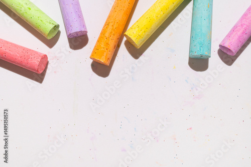 Multicolored bright crayons for drawing on light gray background flat lay top view. Children's chalk close-up. Concept of creativity, child development, back to school