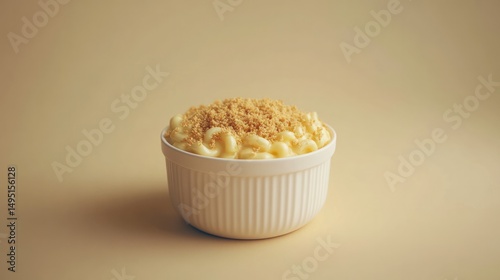 Creamy vanilla custard dessert topped with golden cookie crumbs served in a white ceramic ramekin on a neutral beige background photo