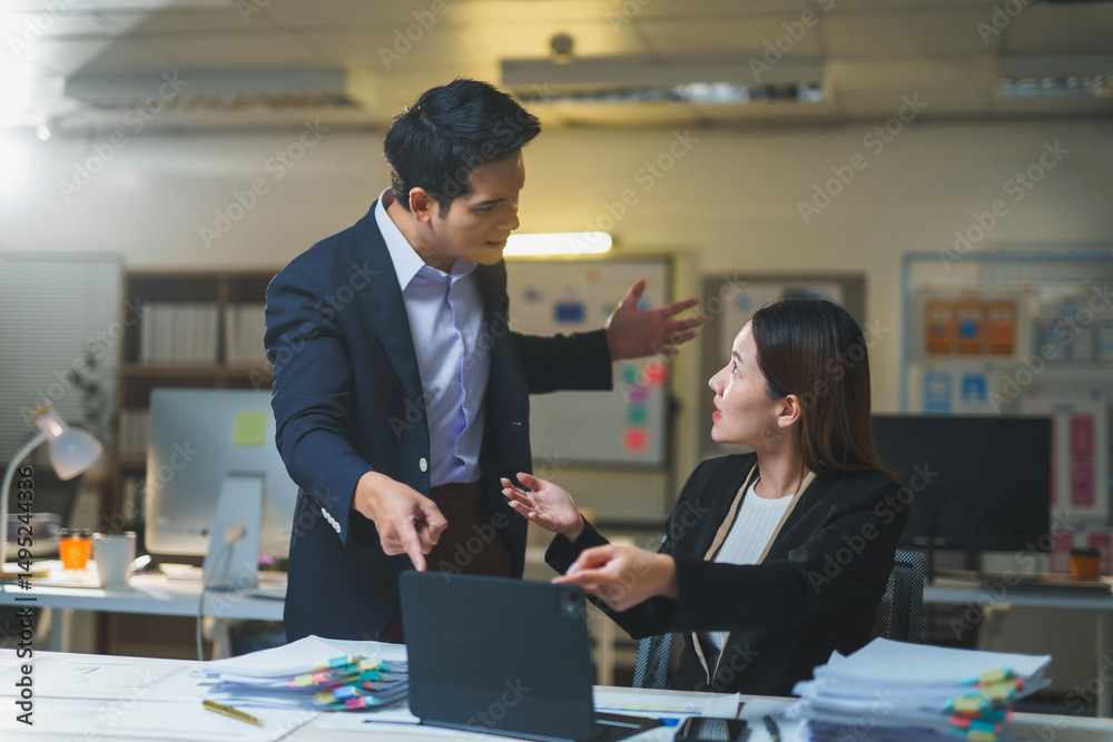 Fototapeta premium Businessman and businesswoman arguing and discussing work related issues in an office setting, showcasing tension and frustration over a project