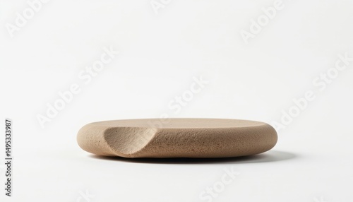 A uniquely shaped light brown stone object with a carved indentation
