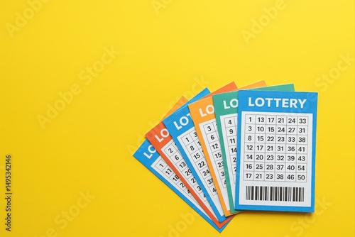 Many colorful lottery tickets are fanned out on a yellow background, suggesting luck, gambling, and the possibility of winning a prize
