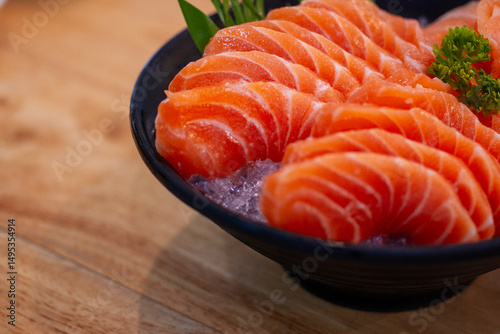 High angle view of salmon seafood in black bowl on table