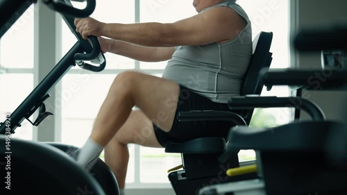 middle-aged fat man is cycling in a gym to lose weight and be healthy.