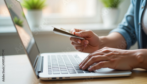 Person shopping online, holding credit card, indoor setting, digital convenience