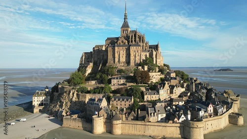 Drone view of Mont-Saint-Michel Abbey nestled in expansive tidal landscape with rural land in France