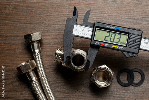 Measuring the diameter of plumbing adapters with an electronic digital caliper, closeup, top view. Plumbing repair concept