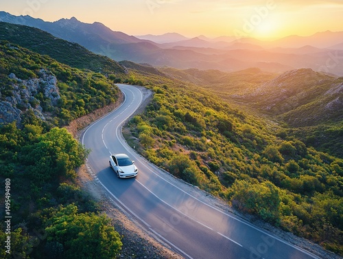 Electric car driving through a scenic mountain road at sunset creates a feeling of freedom