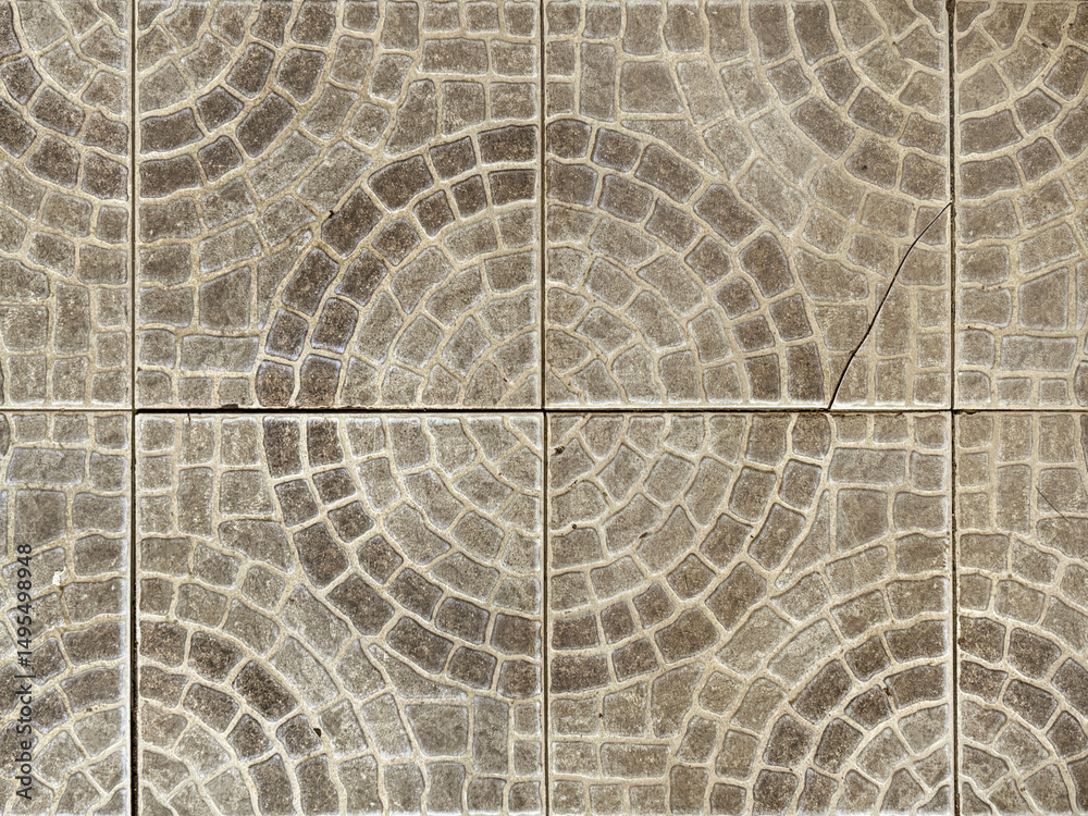 Naklejka premium Close up of round circle shape paving stone in black and grey color. Random cut molded paving stone forming circular pattern cut in square tiles. Seamless stone tiles background texture.