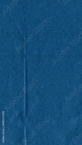 Blue kraft paper noise texture vertical stop motion video. Old page overlay effect background loop animation. Vintage paper texture with crease, stain, grain, dust particles. Empty animated backdrop