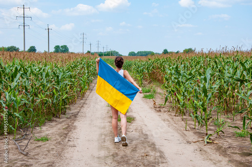 Patriotism and nation. Ukrainian flag memorial day or 24th of August. Girl covered with Ukrainian flag in field. Flag of Ukraine. National flag patriotic girl. Independence day. Patriotic symbol