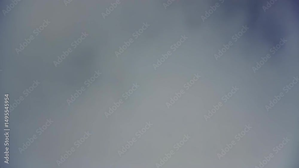 Mountain peaks rising through a thick layer of cloud cover on a foggy day with green hillsides and rocky terrain
