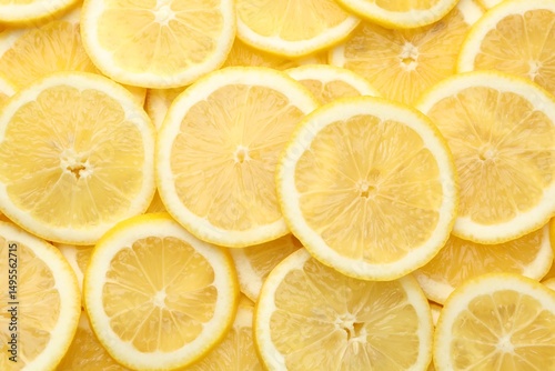 Slices of fresh lemons as background, top view