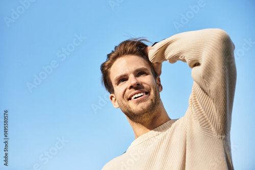 Handsome man enjoying a leisurely stroll under a bright blue sky at sunset photo