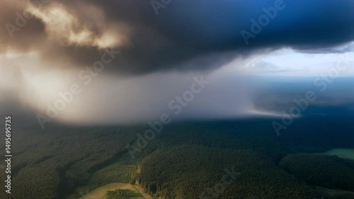 Aerial time lapse of storm clouds rolling over a forest 