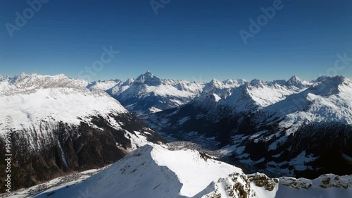 Aerial footage of snow covered mountains against blue sky 