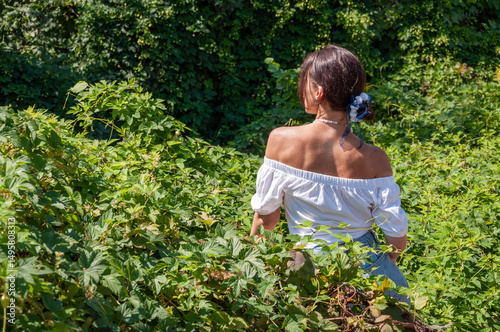 Exotic jungle. Stunning tropical beauty. Herbal medicine. Relaxation retreat. Young Hispanic girl in pearl necklace, green white. Nature therapy. Woman sitting in lush green forest. Banner