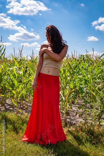 Feminine power and beauty, feminism. Young woman in cornfield under blue sky. Nature escape. Summer fashion. Spanish girl in vibrant red skirt. Rural lifestyle. Young girl, contrast. Beauty skincare