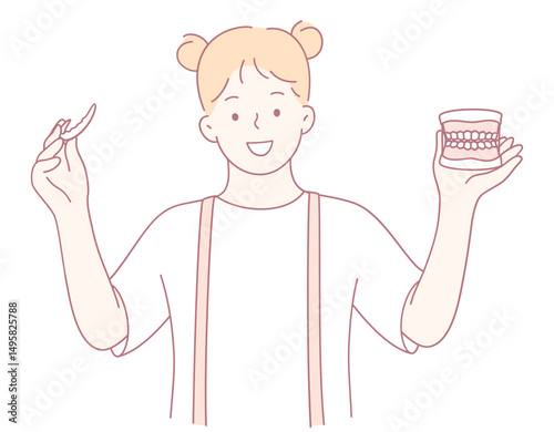 A cheerful girl holds a toothbrush with a dental model, promoting good dental hygiene habits for all