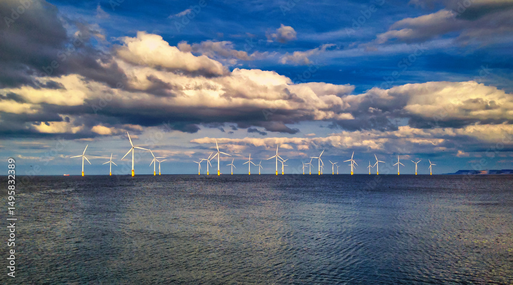 Offshore Wind Turbine in a Windfarm under construction off the England Coast at sunset Offshore Wind Turbine in a Windfarm under construction off the England Coast at sunset