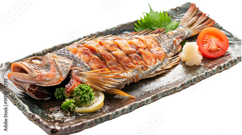 Grilled fish served on a decorative plate with garnishes and fresh vegetables photo