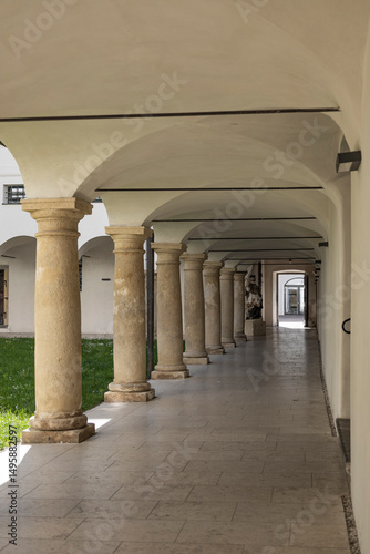 Historic Stone Archway Corridor. A serene walk through a historic stone archway corridor with columns.