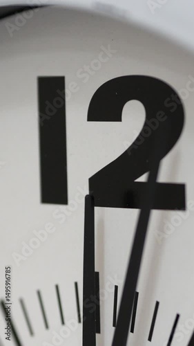 Close-Up Of Clock Hands Nearing Twelve O'Clock On A Modern White Clock Face. Midnight Or Noon, Deadline Concept. Vertical