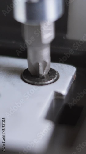 Macro Shot Of A Torx Screwdriver Bit Engaging And Tightening A Screw Into A Metal Component. Repair Or Assembly. Vertical
