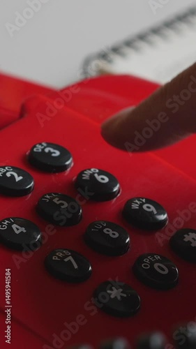 Hand Picks Up Receiver And Dials A Number On A Vintage Red Push-Button Landline Telephone. Communication Concept. Vertical