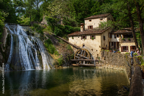 Old mill in the river in Refrontolo, Veneto, Italy, Molinetto della Croda, panorama with a beautiful waterfall in the woods and with people.