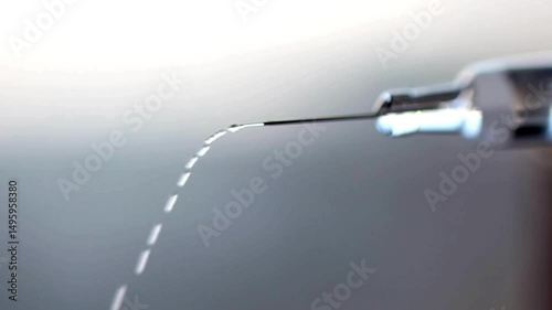 closeup droplets of clear liquid fall and spurt from syringe medication medical