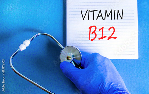 Vitamin B12 symbol. Concept words Vitamin B12 on beautiful white note. Doctor's hand in blue medical glove. Stethoscope. Beautiful blue background. Medical healthy lifestyle Vitamin B12 concept.