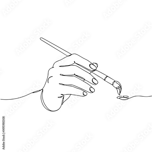 Hand holding a paintbrush with paint and copy space