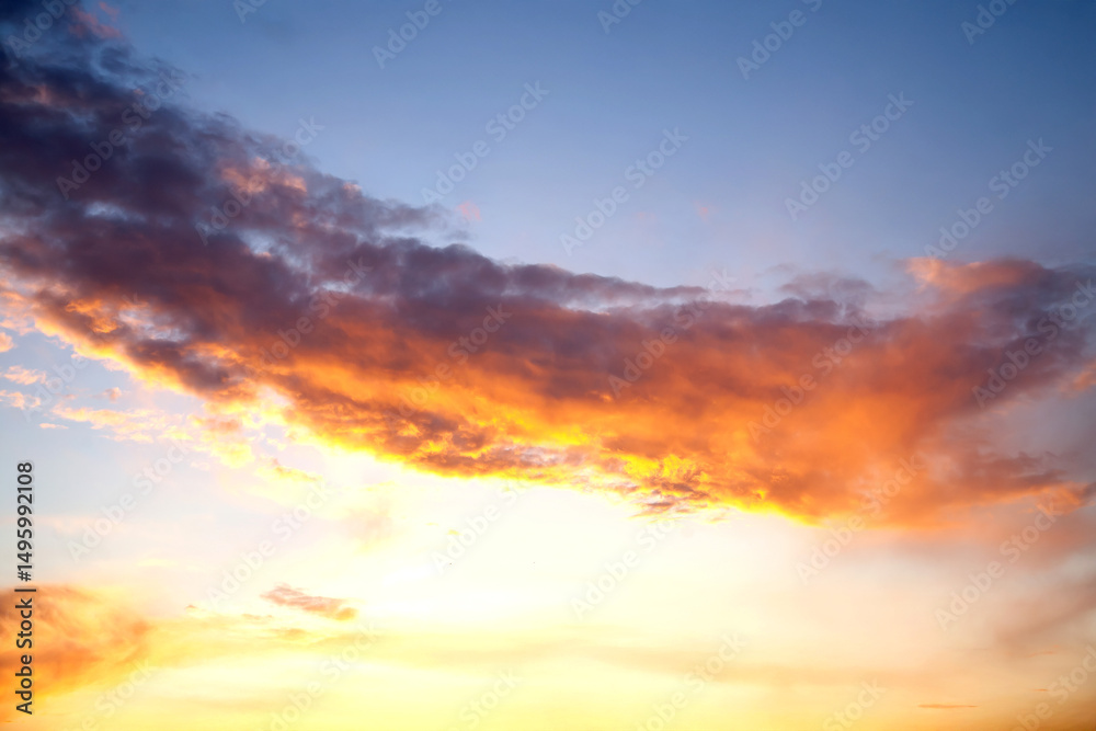 Obraz premium Sunset sky with layered clouds in various shades of blue, gray, and gold. A mesmerizing display of nature’s beauty, perfect for backgrounds or atmospheric concepts.