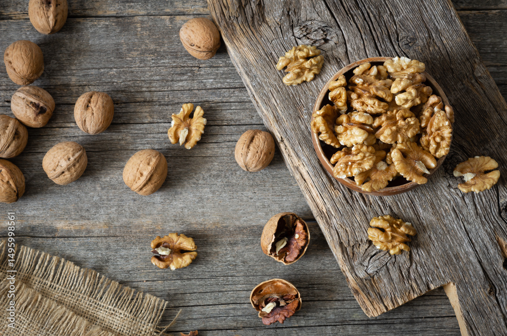 Fototapeta premium Ripe and fresh walnut kernels in bowl without shell on rustic table, healthy nut food for brain