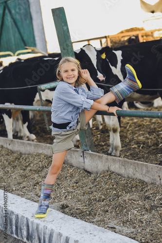 Vertical photo of farmer girl has fun  on a farm in summer. Child and animal friendship. Happy childhood