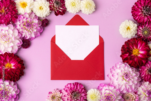 Creative layout made of flowers dahlias with a vinous envelope with space for text. Floral Greeting card. Nature trendy decorative design. Flat lay.