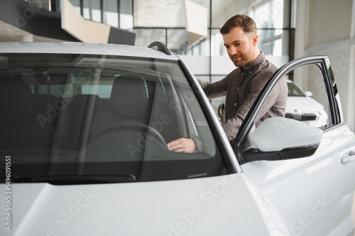 Customer choosing new car in dealership showroom