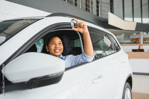 Happy african american woman showing car key in new vehicle