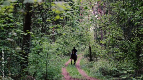 cowboy in a hat rides a horse through the forest