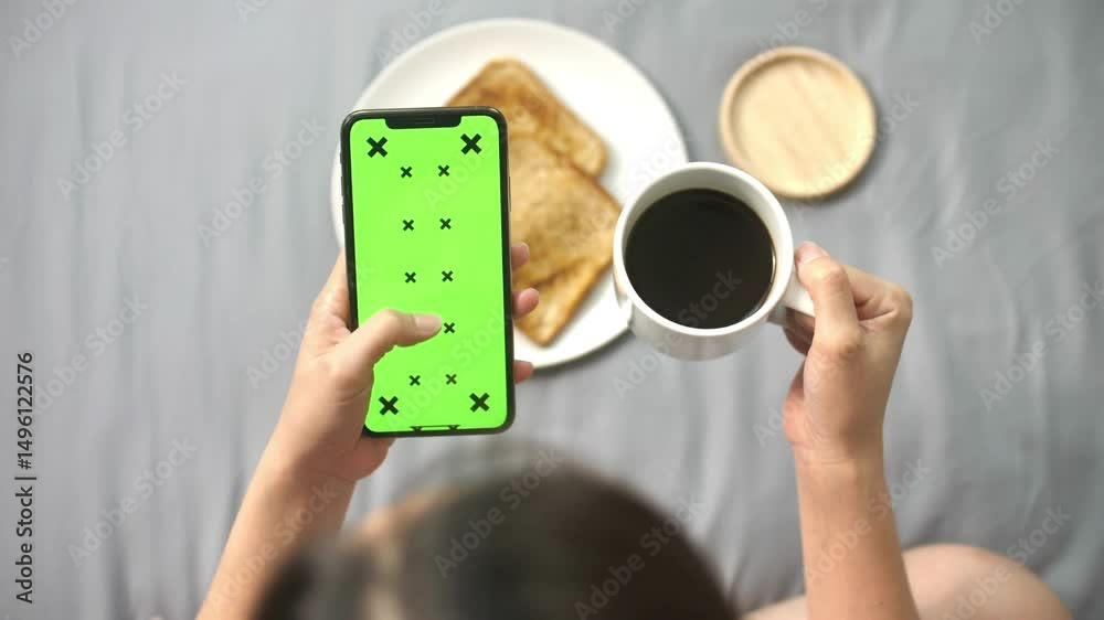 Green screen phone and human hand, woman has a green screen smart phone in cafe table while drinking coffee and breakfast mock up