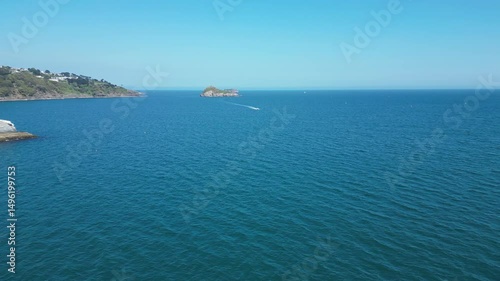 Torbay, South Devon, England: DRONE VIEWS: A speedboat heads across the bay in the direction of Torquay; Thatcher Rock is in the background. Torbay is a popular UK holiday destination (Clip 4).